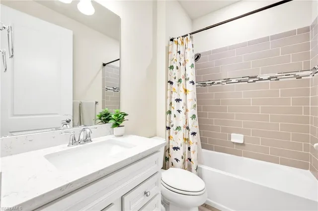 a bathroom with a sink a toilet a mirror a bathtub and shower