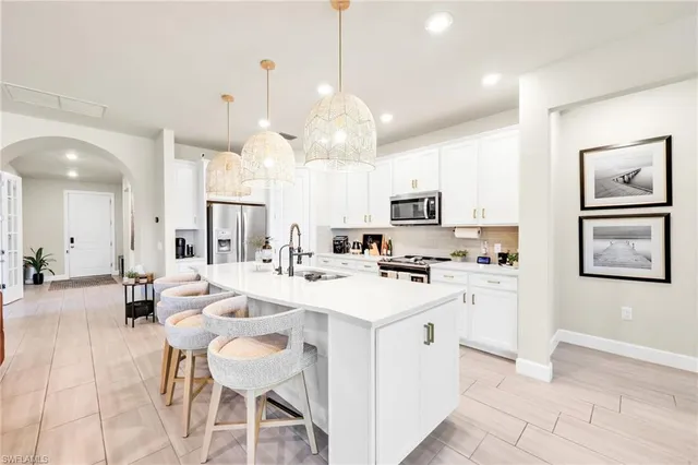 a kitchen with stainless steel appliances a stove a sink a refrigerator a center island a stove and a cabinets