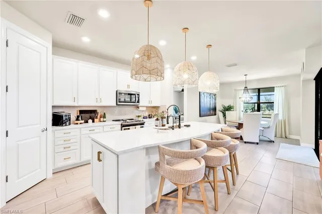 a large kitchen with lots of counter space and chairs