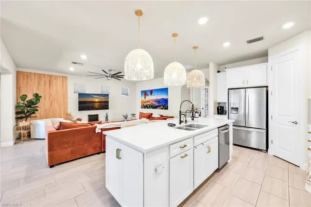 a kitchen with stainless steel appliances a stove refrigerator sink and a mirror