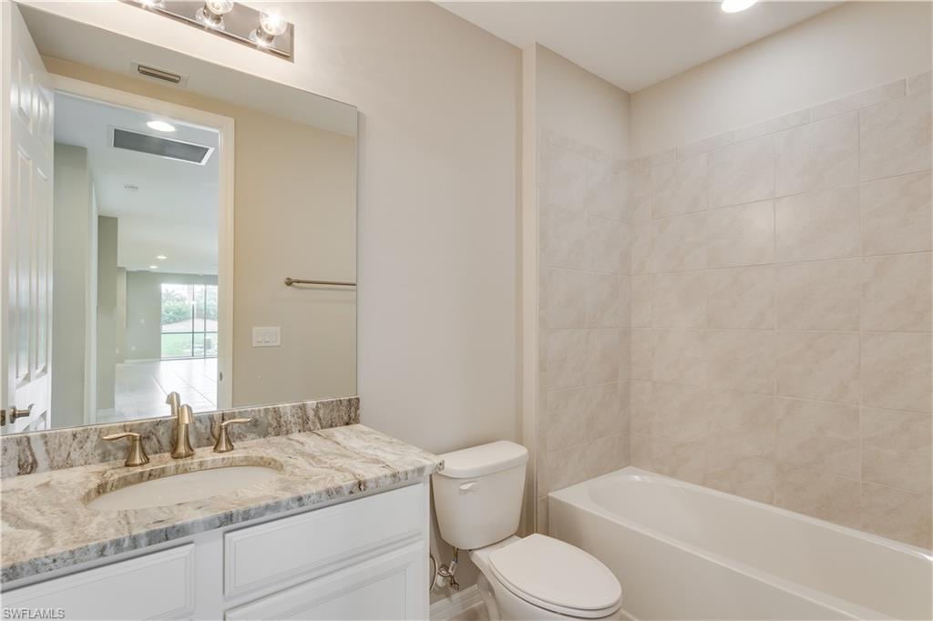 14863 Edgewater Circle Naples, FL 34114 - Photo 17 of 35 a bathroom with a granite countertop sink toilet and shower