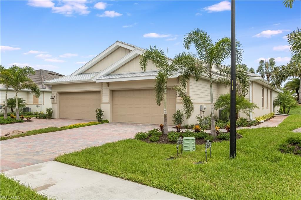 14863 Edgewater Circle Naples, FL 34114 - Photo 19 of 35 a front view of a house with garden