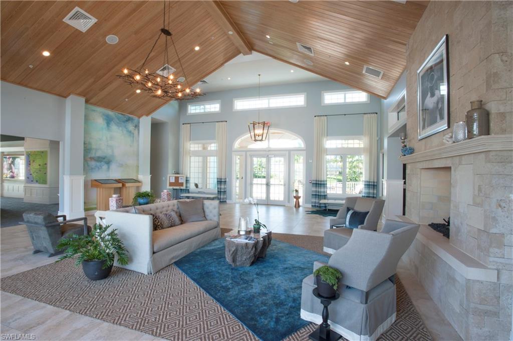 14863 Edgewater Circle Naples, FL 34114 - Photo 22 of 35 a living room with fireplace furniture and a chandelier