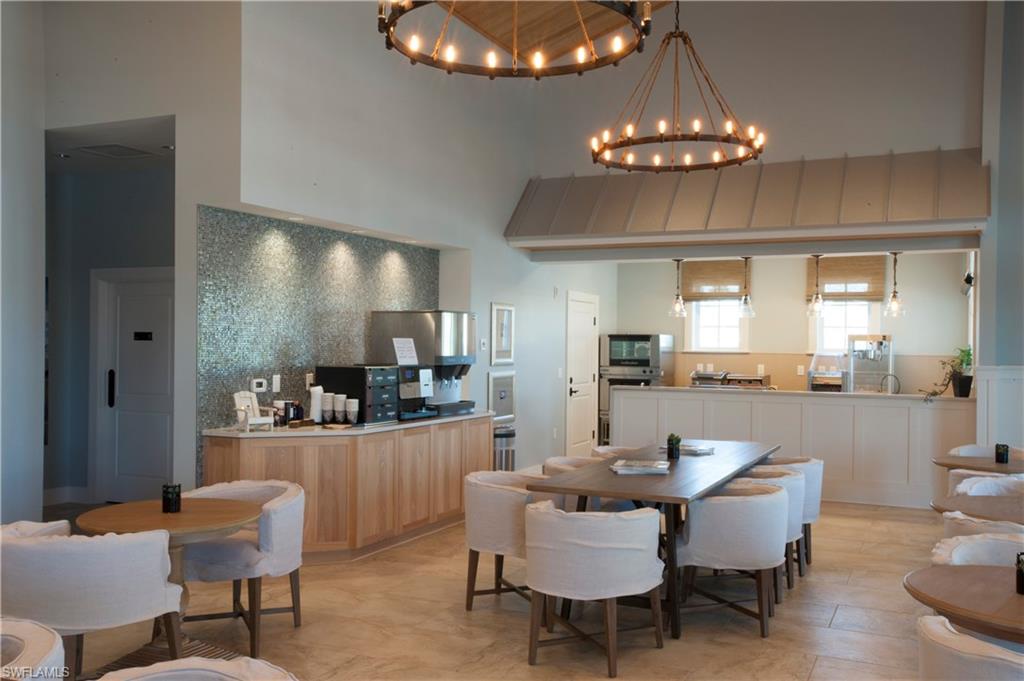 14863 Edgewater Circle Naples, FL 34114 - Photo 29 of 35 a dining room with wooden floor a chandelier a glass table and chairs