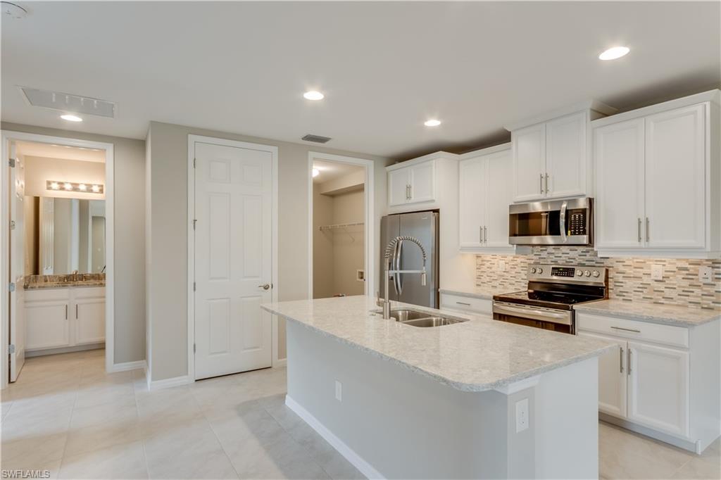 14863 Edgewater Circle Naples, FL 34114 - Photo 3 of 35 a kitchen with stainless steel appliances a refrigerator sink and microwave