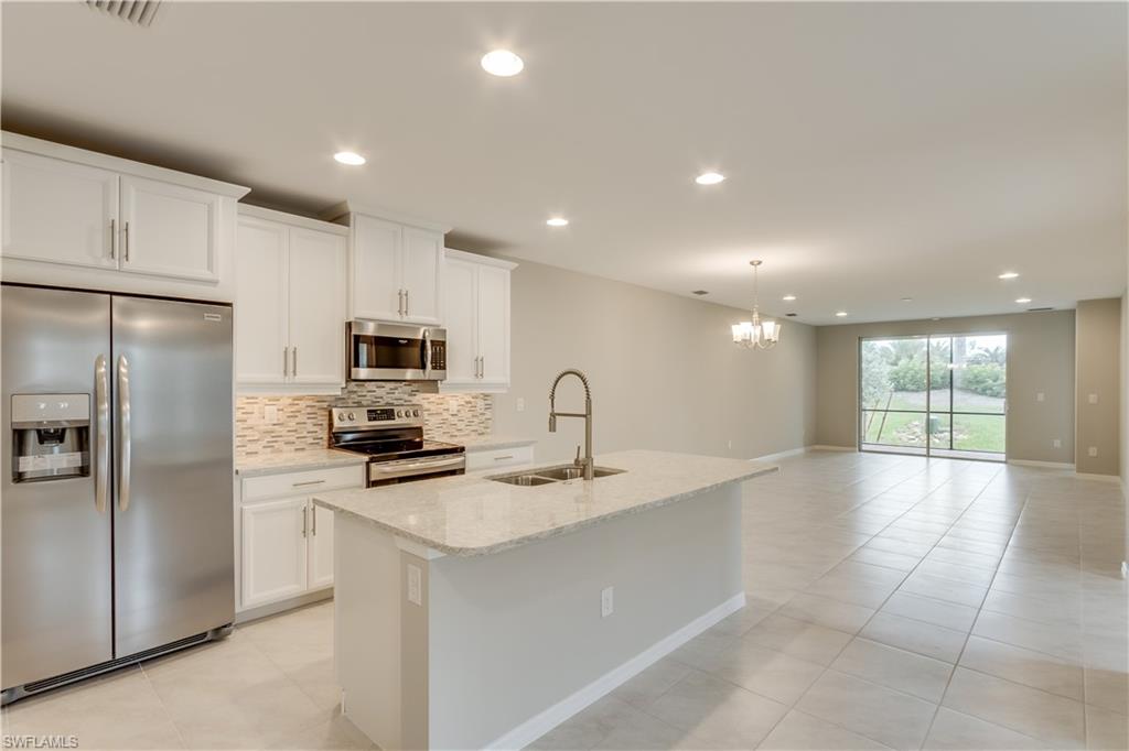 14863 Edgewater Circle Naples, FL 34114 - Photo 4 of 35 a kitchen with stainless steel appliances a refrigerator sink and microwave