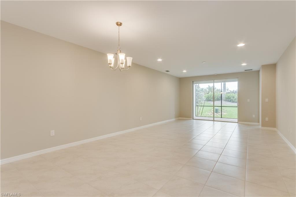 14863 Edgewater Circle Naples, FL 34114 - Photo 9 of 35 an empty room with chandelier and windows