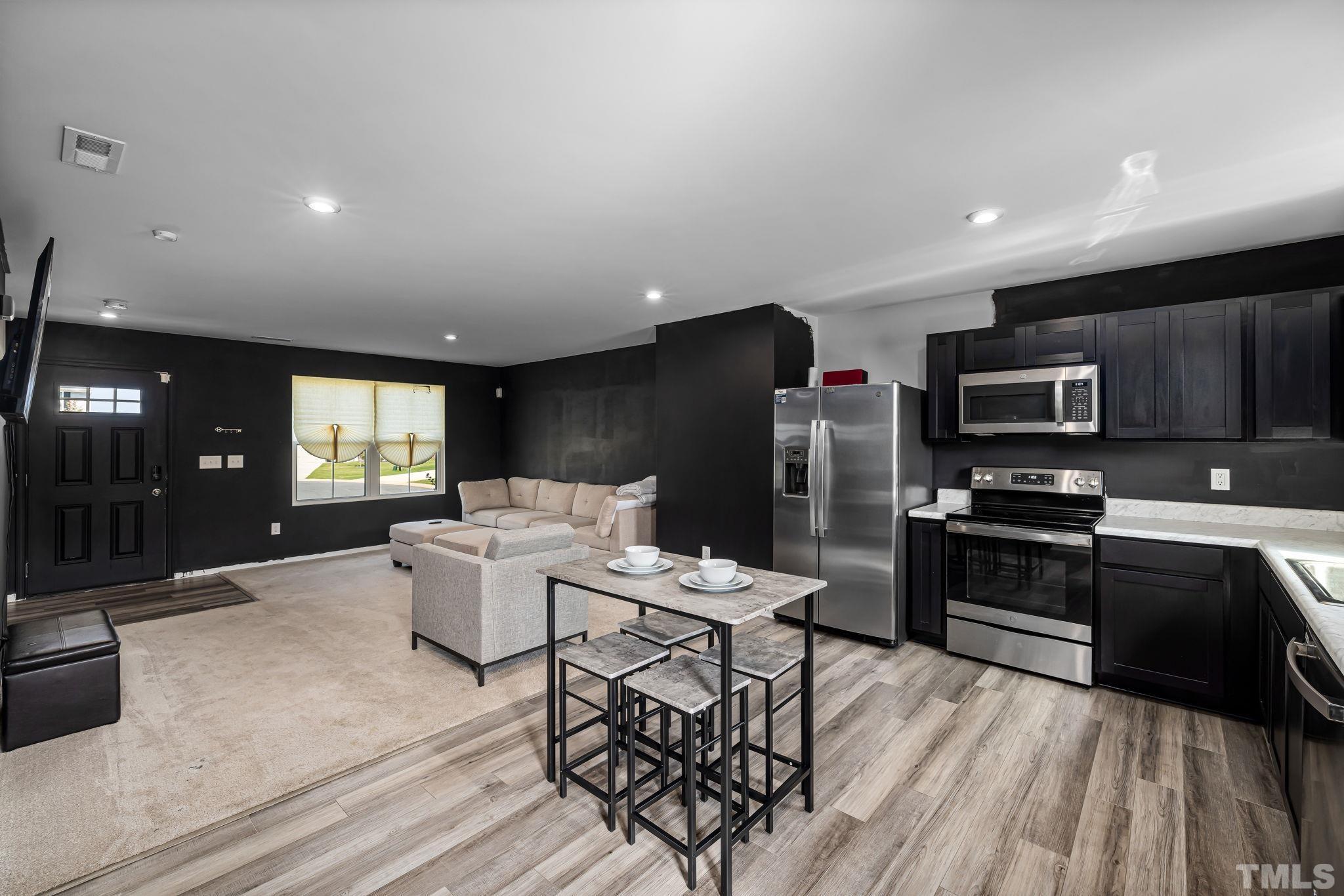 32 Powder Court Angier, NC 27501 - Photo 6 of 14 a living room with stainless steel appliances furniture a kitchen view and a wooden floor