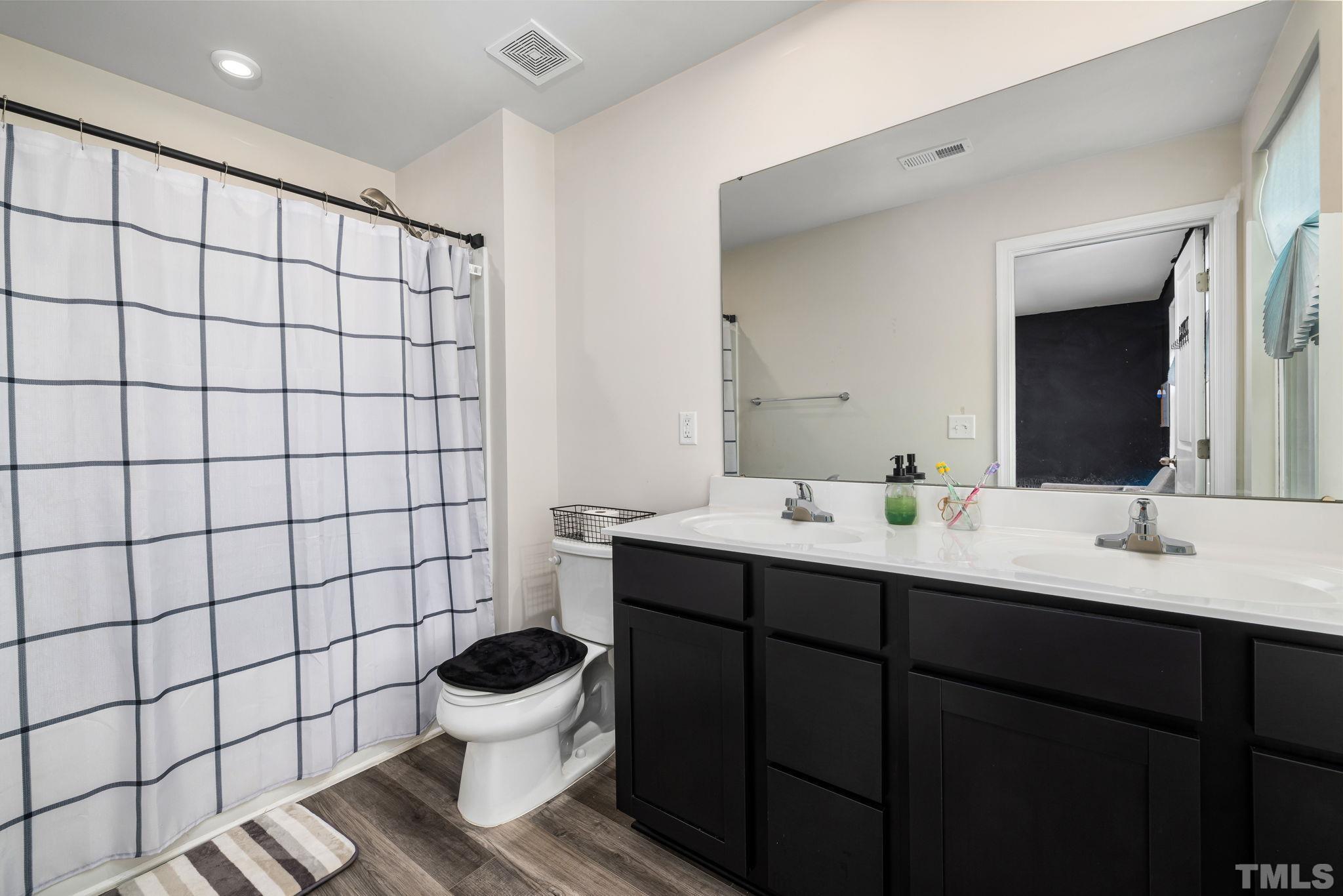 32 Powder Court Angier, NC 27501 - Photo 9 of 14 a bathroom with a sink mirror toilet and a shower