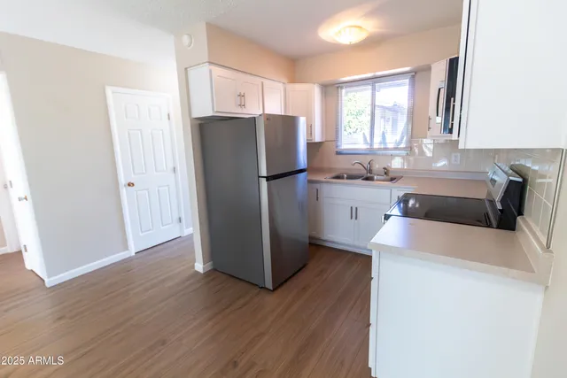 a kitchen with a refrigerator sink and wooden cabinets