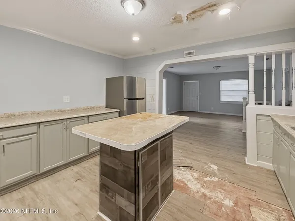 a kitchen with a sink refrigerator and microwave