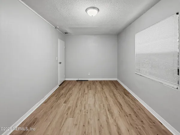 a view of a room with wooden floor and window