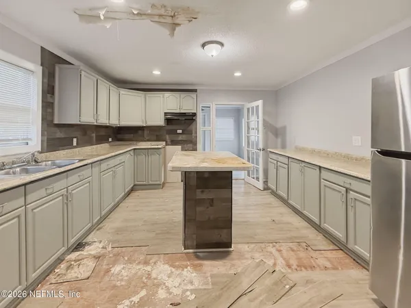a large kitchen with kitchen island a sink stainless steel appliances and cabinets