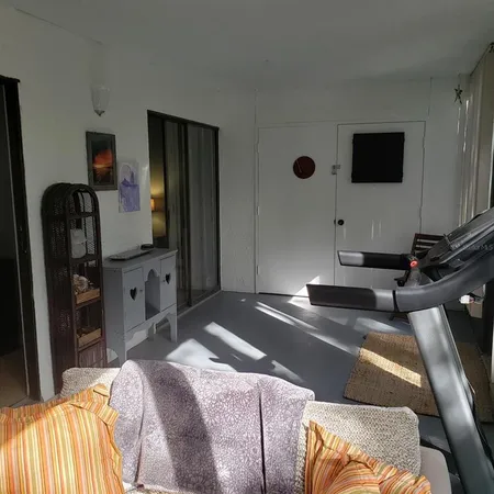 a bedroom with a bed and a flat tv screen on dresser