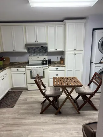 a kitchen with a sink a stove and white cabinets