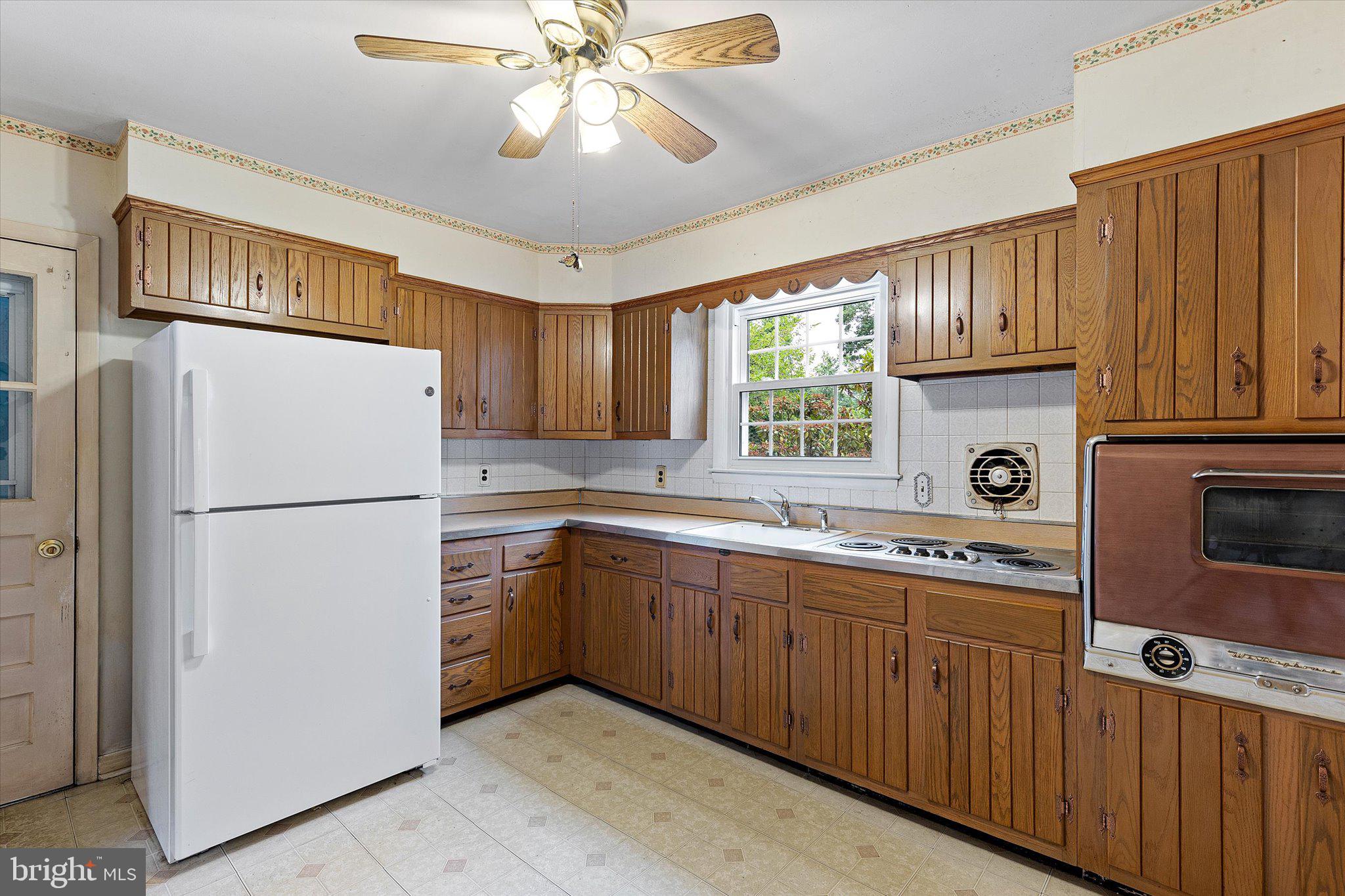 2404 Rambler Road Wilmington, DE 19810 - Photo 8 of 21 a kitchen with stainless steel appliances granite countertop a refrigerator a sink dishwasher a stove and a dining table with wooden cabinet
