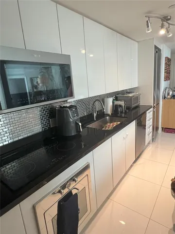 a kitchen with granite countertop a sink and cabinets
