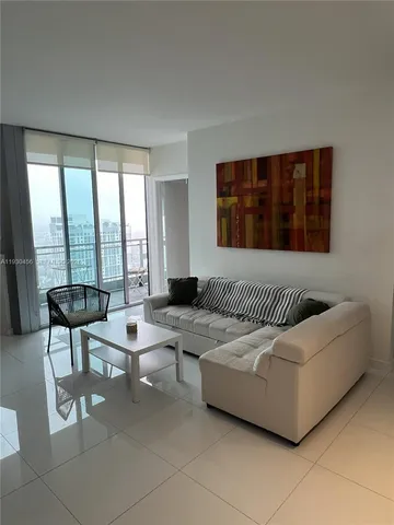 a bedroom with furniture and a large window