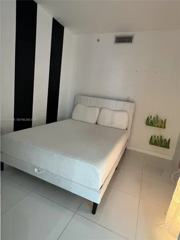 a bedroom with a bed and a potted plant