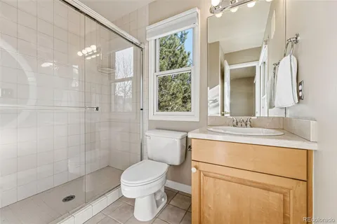 a bathroom with a granite countertop sink a toilet and shower