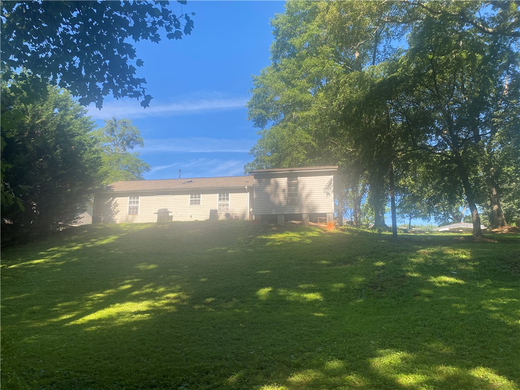 756B Maple Drive Greer, SC 29651 - Photo 2 of 4 A verdant, rolling lawn unfurls behind a charming single-story residence, shaded by mature trees.