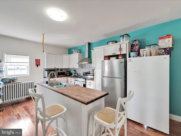 a kitchen with a refrigerator a stove a dining table and chairs
