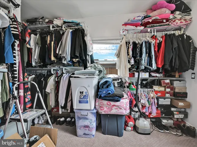 a view of walk in closet with clothes