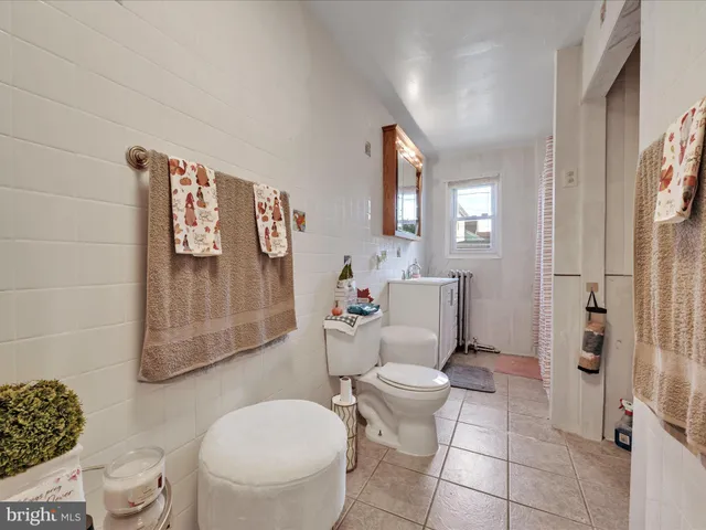 a bathroom with a toilet sink and shower curtain