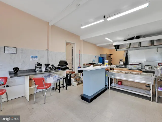 a room with table chairs and white cabinets