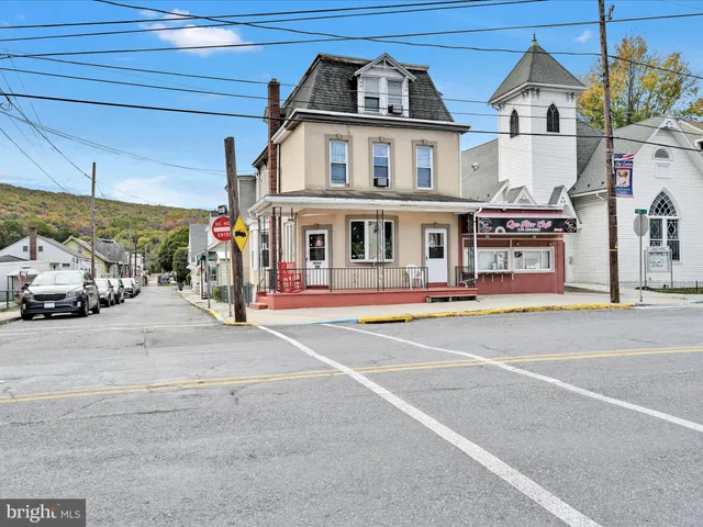 a front view of a building with cars parked