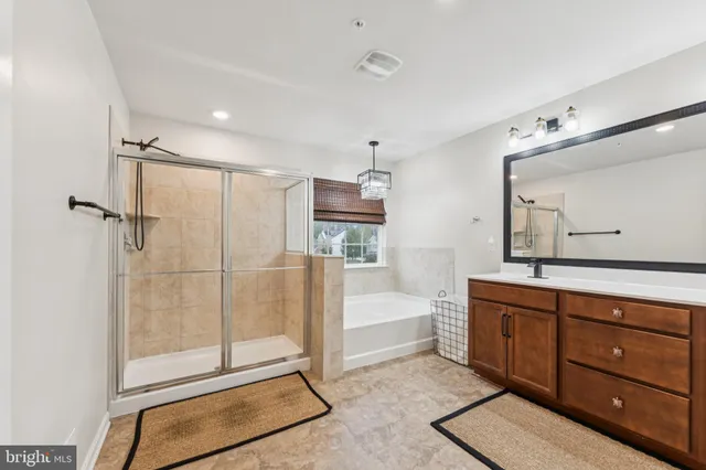 a bathroom with a tub sink and mirror