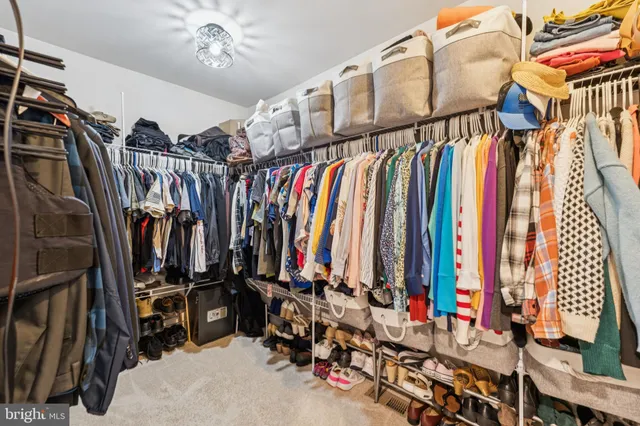 a view of walk in closet with clothes
