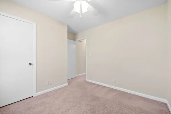 an empty room with a chandelier fan