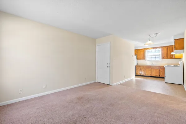 an empty room with a kitchen and sink