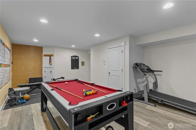 a room with pool table and a wooden floor