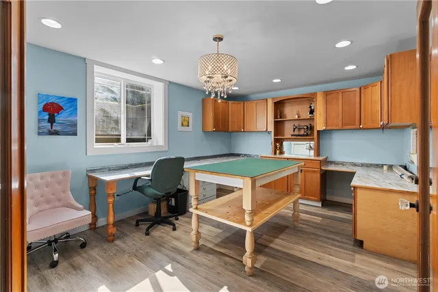 a kitchen with stainless steel appliances granite countertop a stove top oven a sink dishwasher and white cabinets with wooden floor