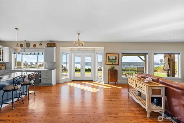 a view of a living room and kitchen with furniture wooden floor and windows