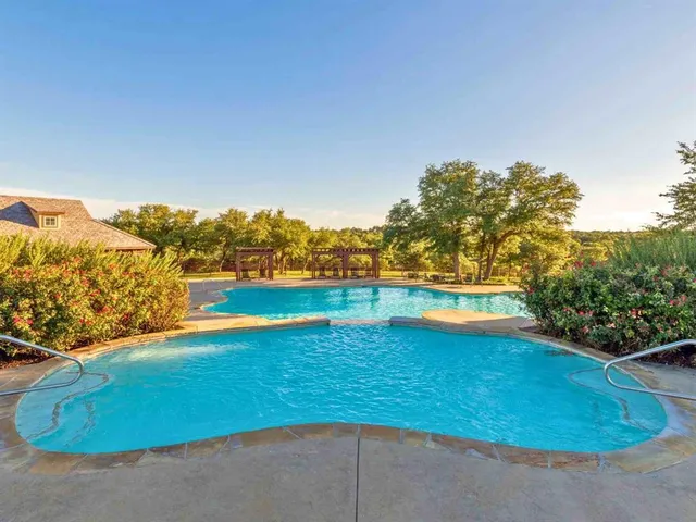 a view of a swimming pool with an outdoor seating and a yard
