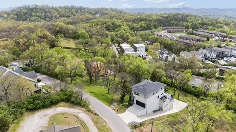 an aerial view of a house with a yard and lake view