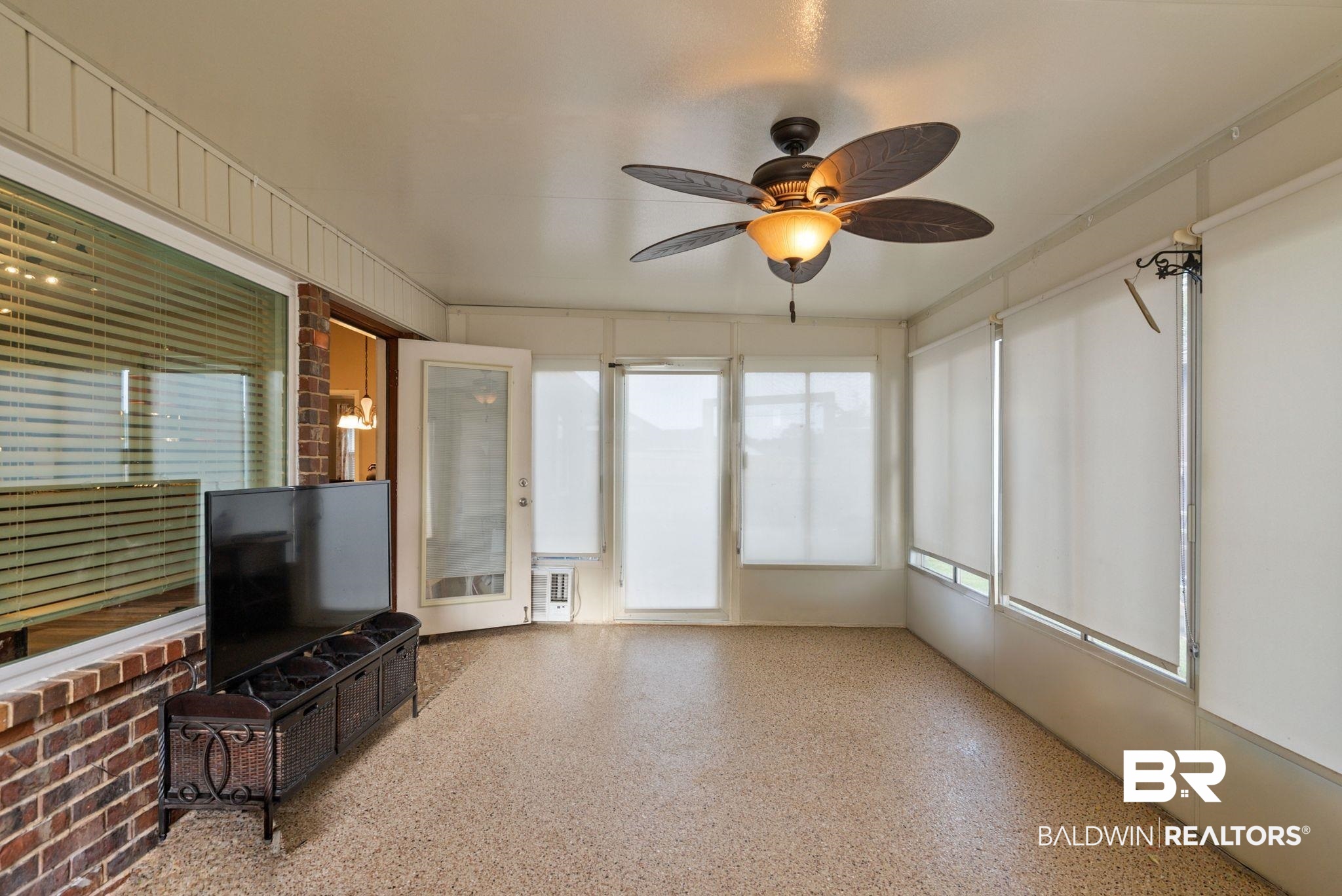 562 Vestige Mews Foley, AL 36535 - Photo 38 of 54 Spacious enclosed patio featuring a ceiling fan with integrated lighting, multiple windows with roller shades, and a durable speckled floor