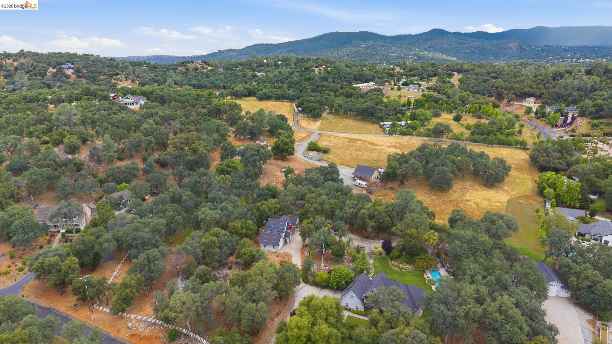 18450 Lambert Lake Road Sonora, CA 95370 - Photo 83 of 87 Expansive property featuring rolling hills, mature trees, a private driveway, and a residential structure with a swimming pool