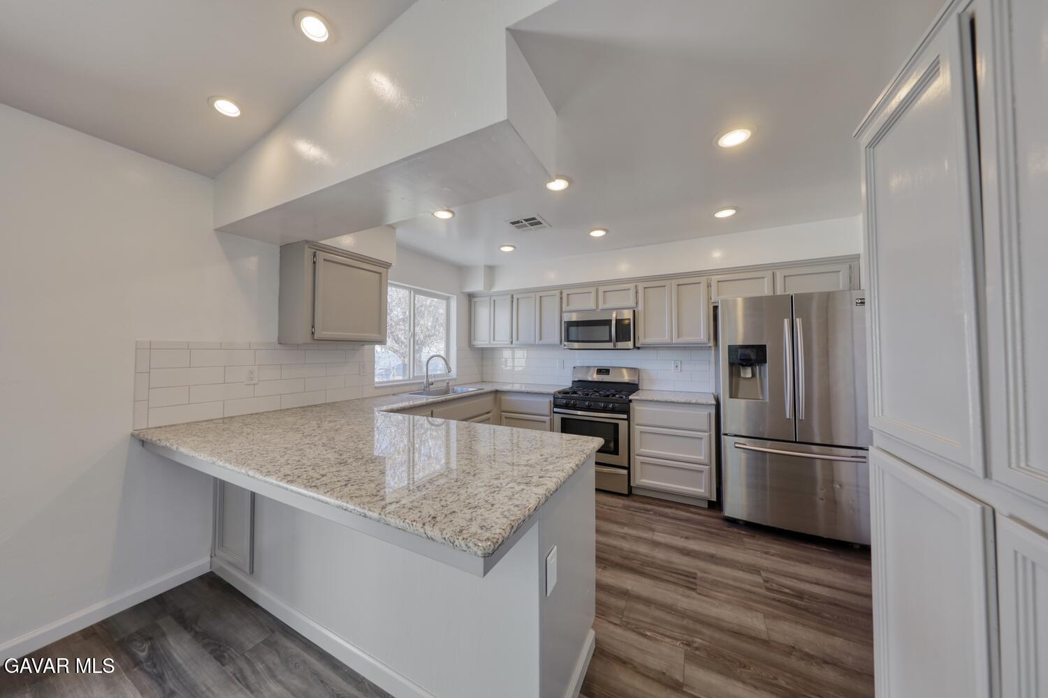 26801 Cabriolet Court Tehachapi, CA 93561 - Photo 12 of 60 a kitchen with kitchen island a sink stove and refrigerator