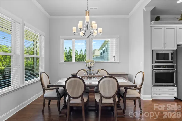 a view of a dining room with furniture a chandelier and wooden floor