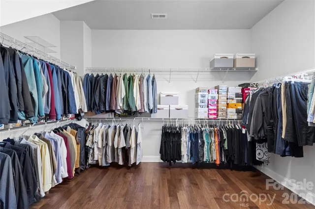 a view of walk in closet with clothes and shoes