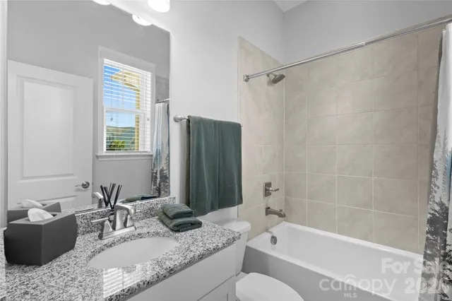 a bathroom with a granite countertop tub sink and mirror