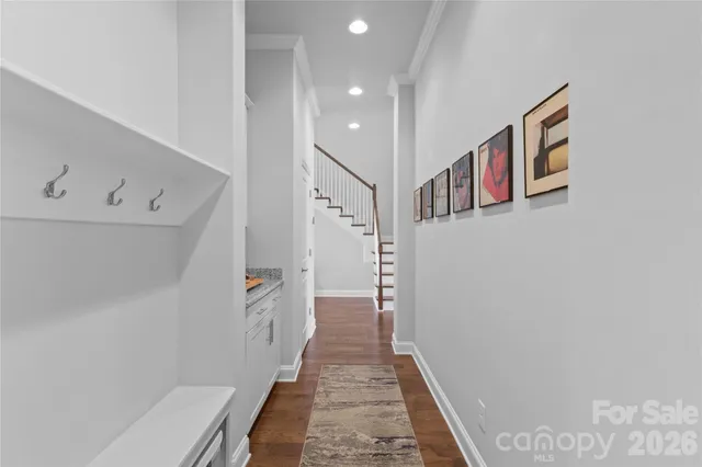 a hallway with a white cabinets and wooden floor