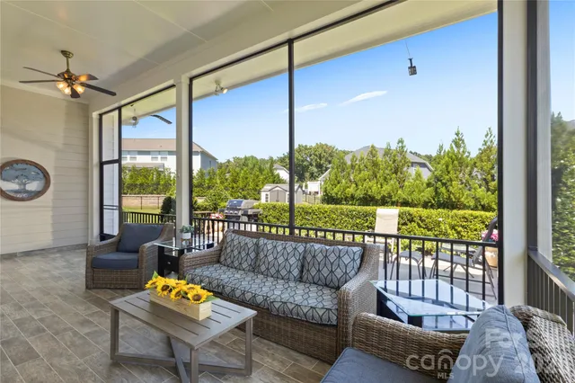 a living room with furniture and a floor to ceiling window