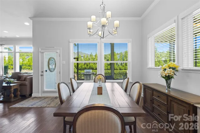 a view of a dining room with furniture a chandelier and wooden floor