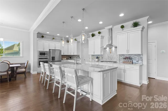 a large kitchen with kitchen island a sink table and chairs