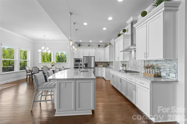 a large kitchen with stainless steel appliances kitchen island granite countertop a large center island attached withe living room